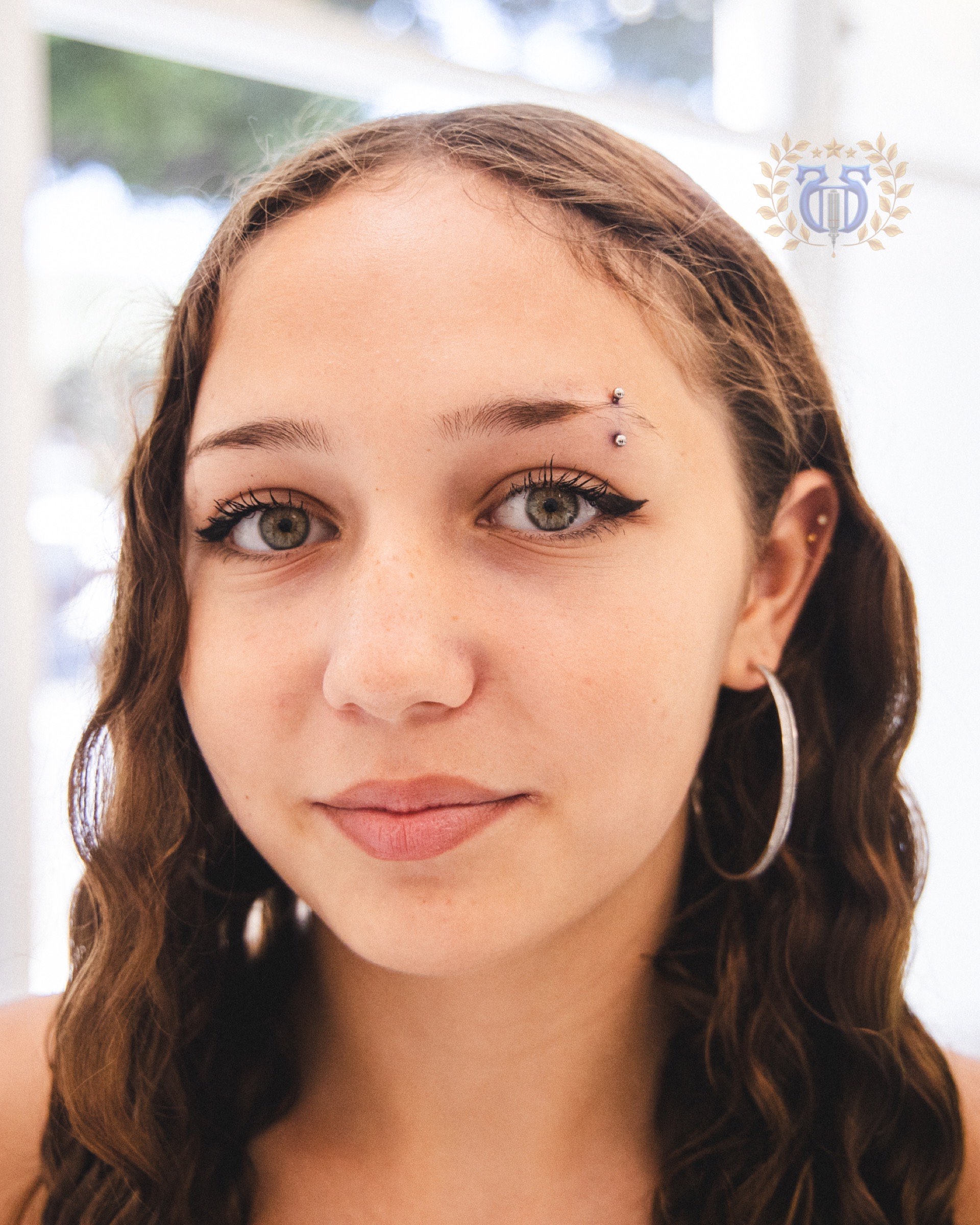 Small silver eyebrow piercing portrait at Apollo Tattoo and Piercing Studio