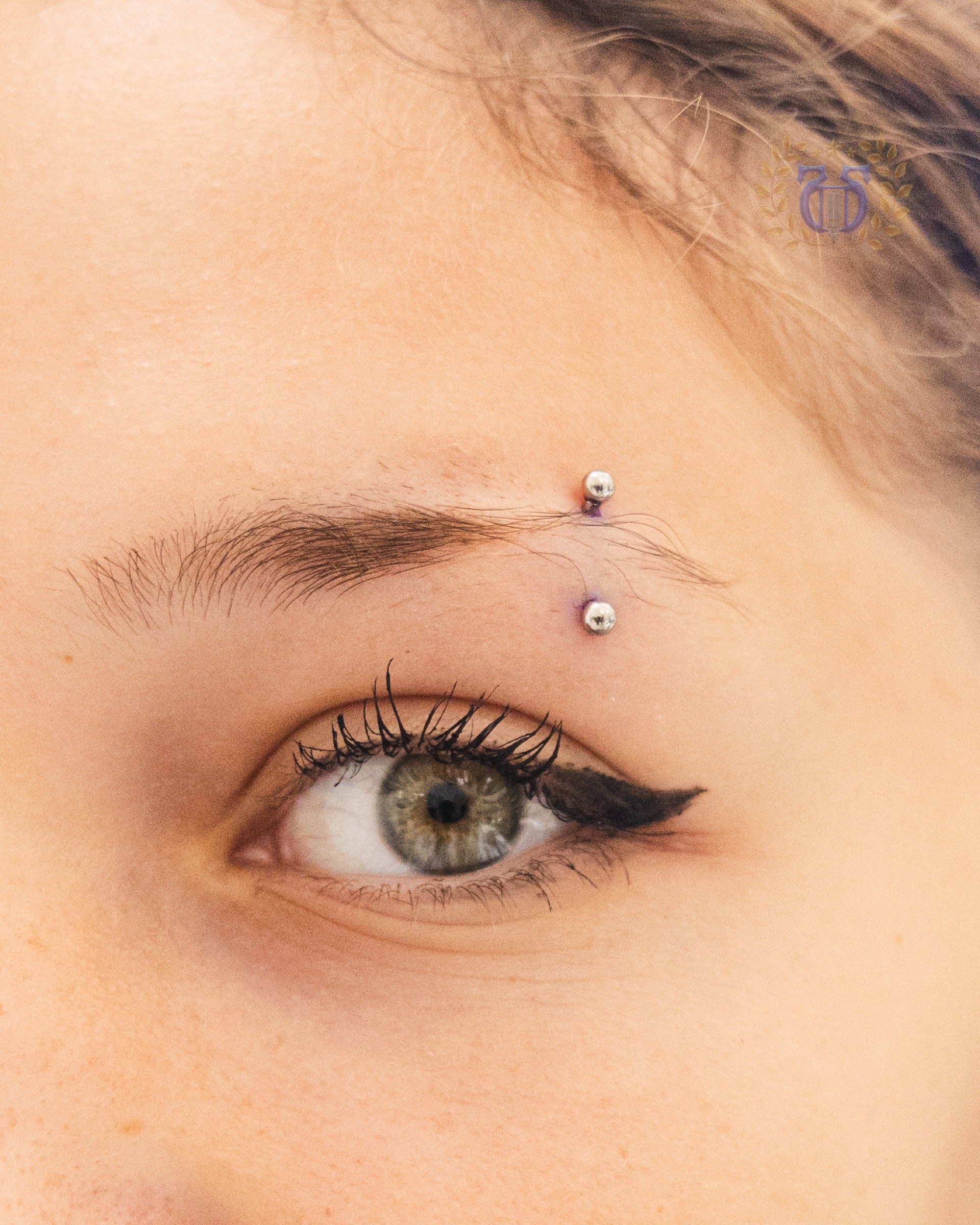 Silver curved barbell eyebrow piercing detail at Apollo Studio Los Angeles