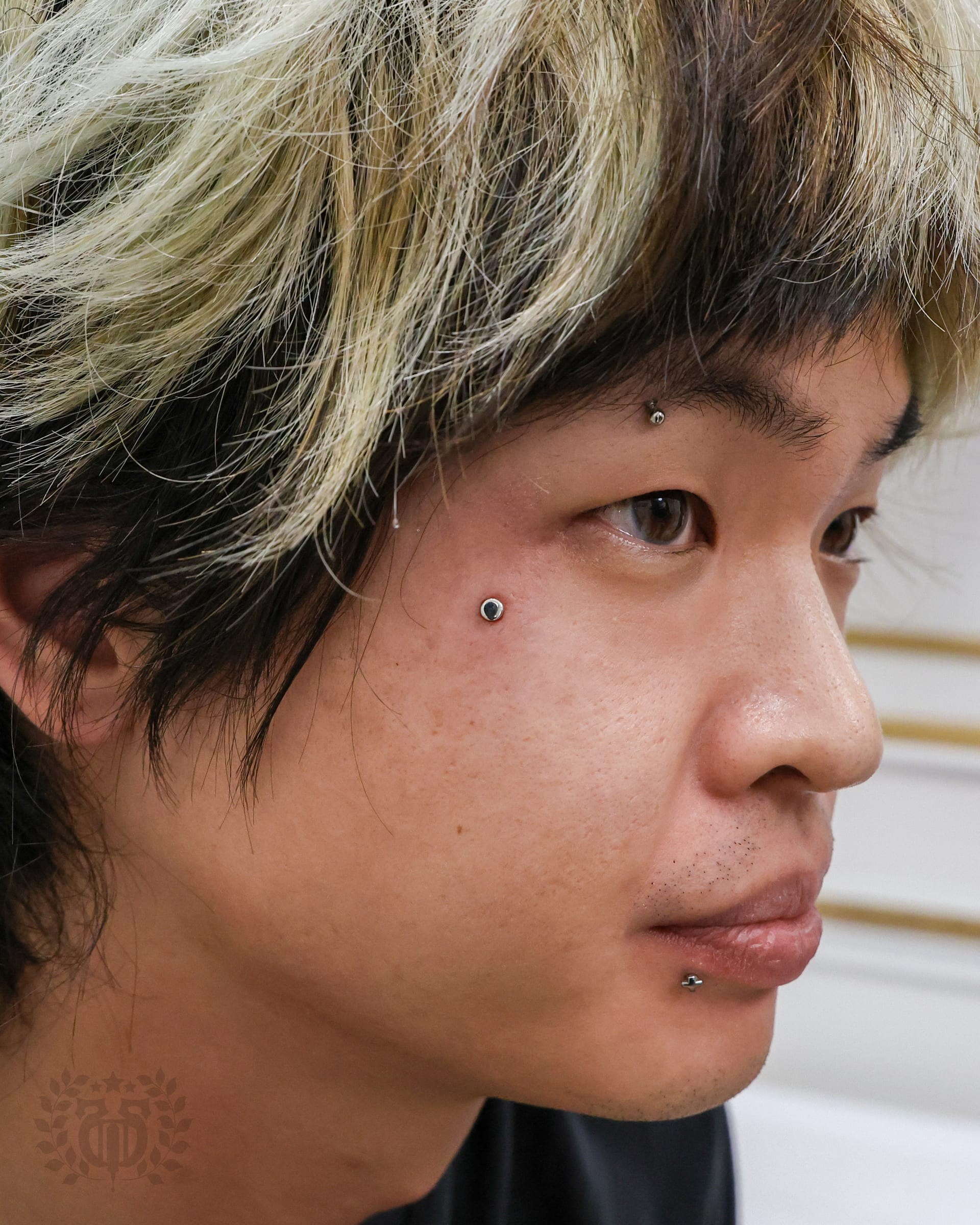 Dermal anchor CZ near temple on female client with nose stud at Apollo Tattoo and Piercing