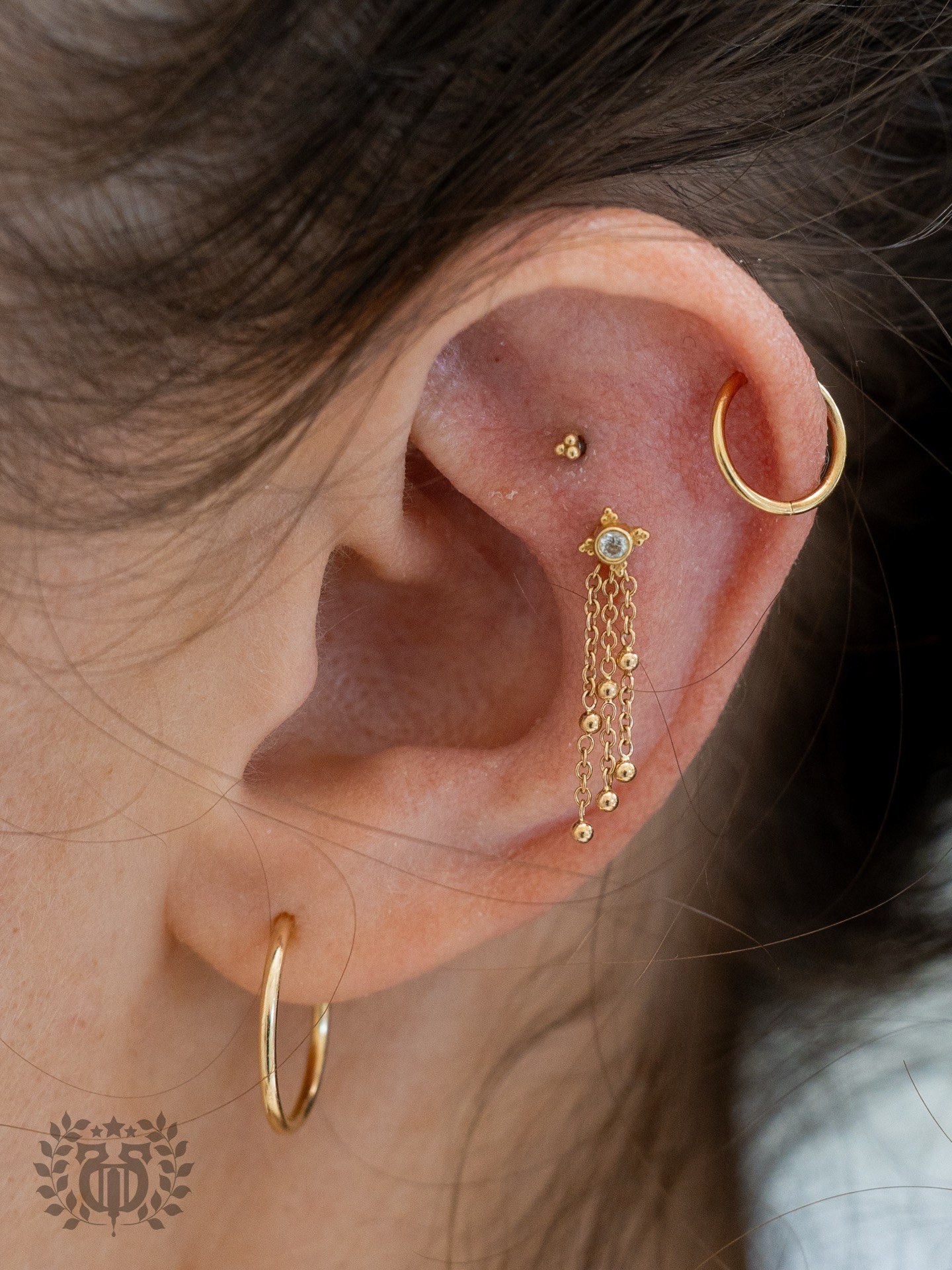 Helix cartilage piercing with gold chain jewelry at Apollo Studio Los Angeles