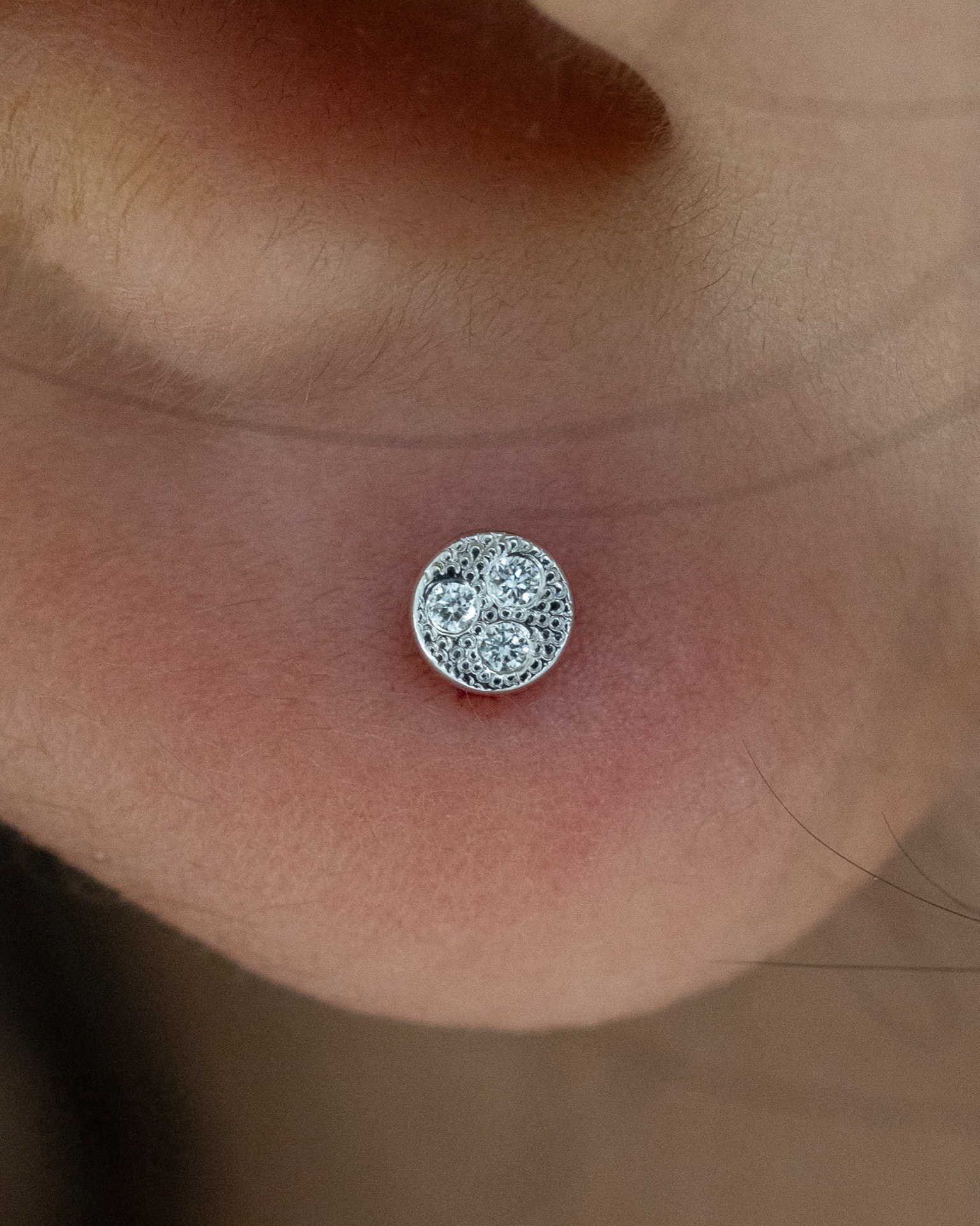 Lobe piercing with delicate leaf stud at Apollo Studio Los Angeles