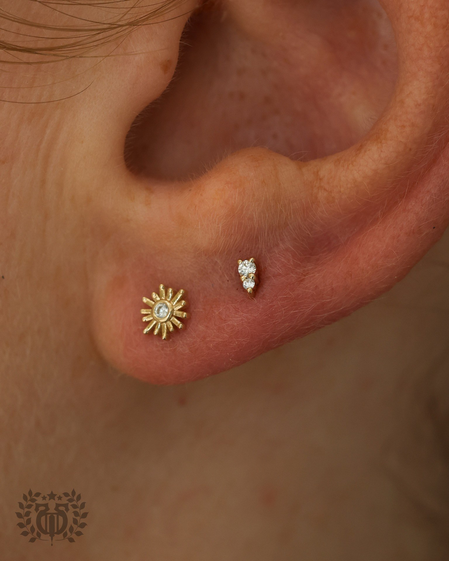 Lobe piercing with sunburst stud at Apollo Studio Los Angeles