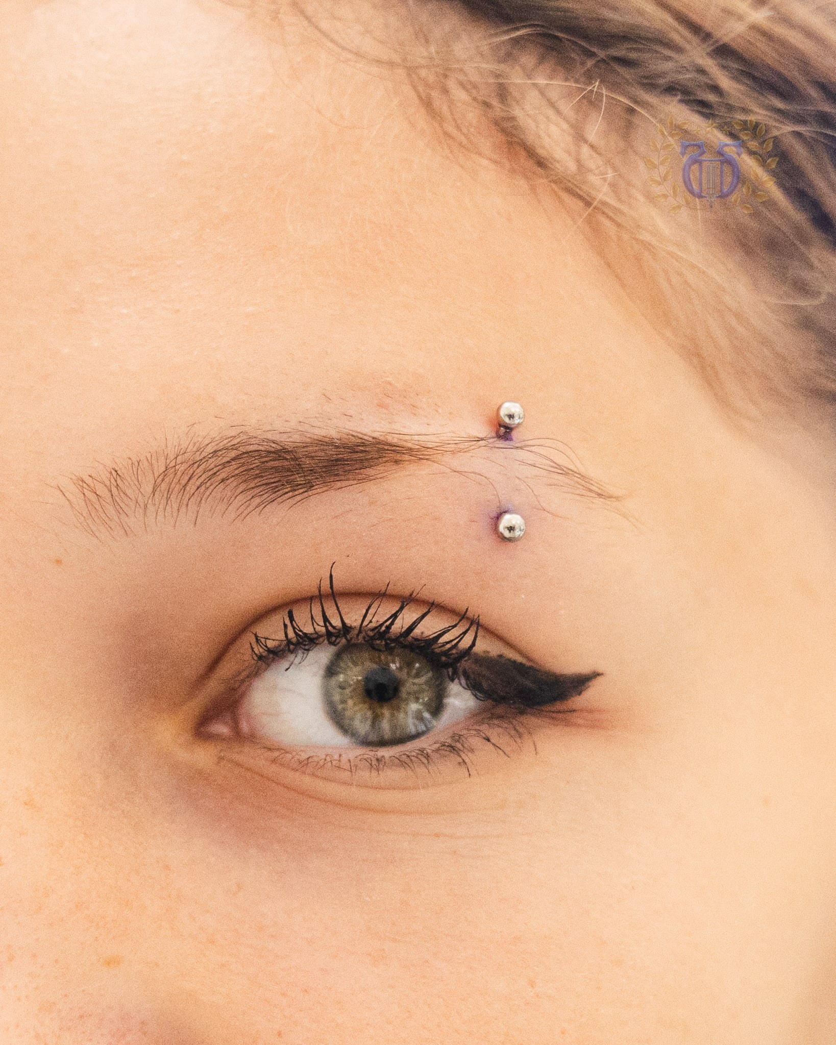 Silver curved barbell eyebrow piercing detail at Apollo Studio Los Angeles
