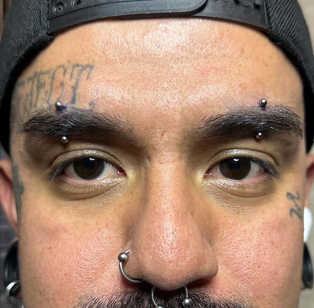Gold ball curved barbell eyebrow piercing at Apollo Studio Los Angeles