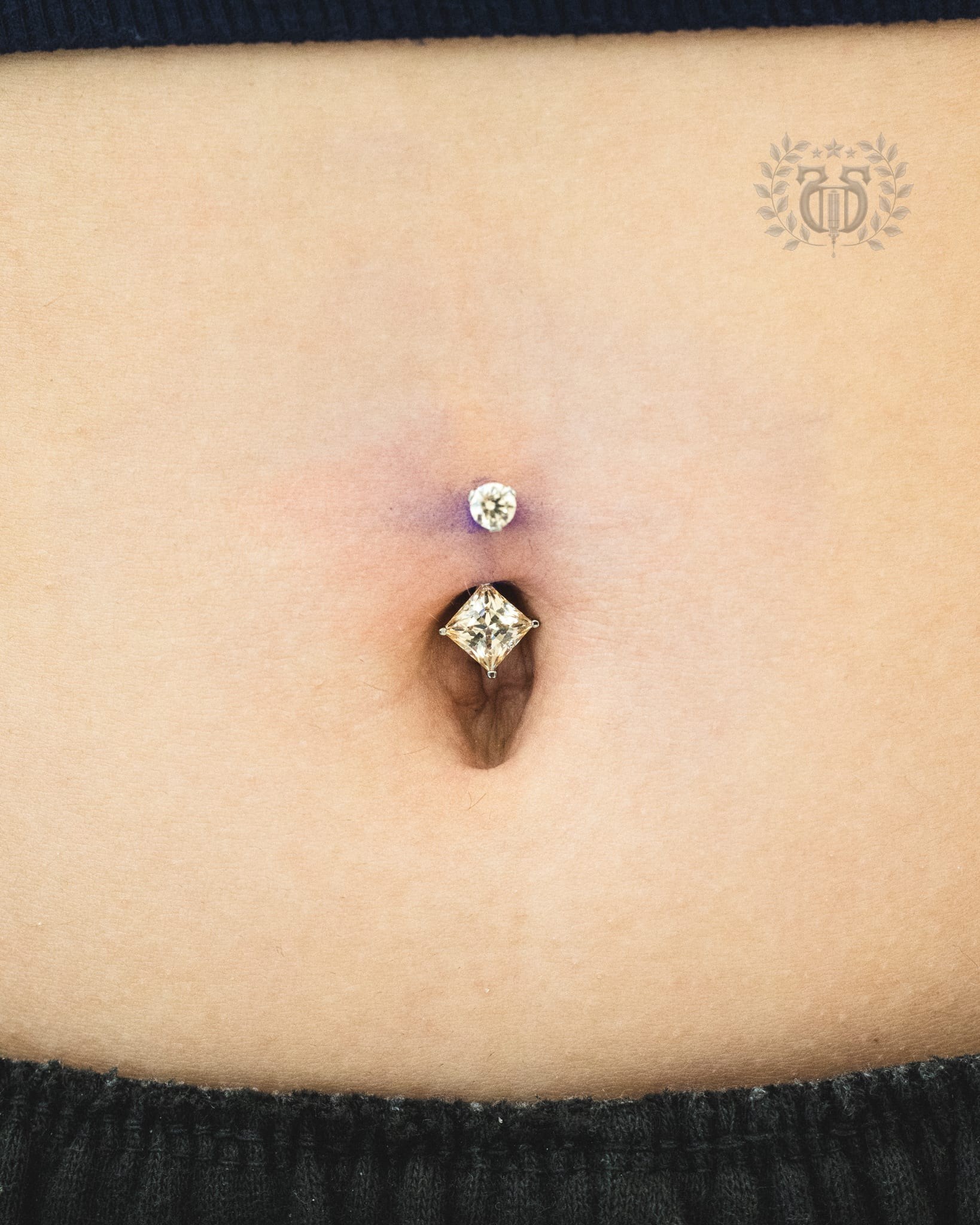 Fresh belly button piercing with CZ dangle curved barbell at Apollo Studio Los Angeles