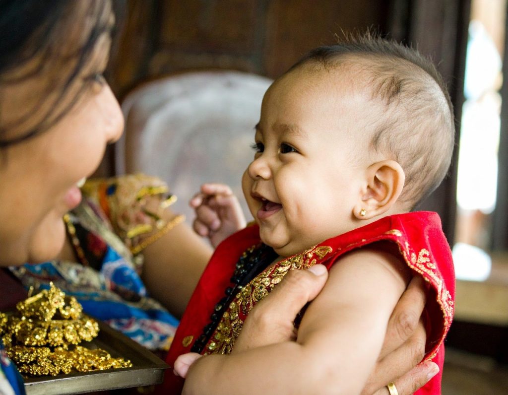 Smiling baby — guidance on the right age for infant ear piercing